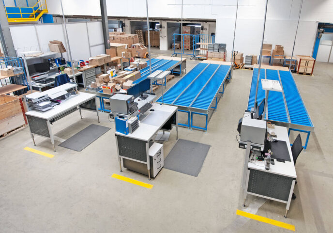 Kommissionierung mit ERGO-Basic Arbeitstischen und Rollenbahnen ERGO-Basic Tische mit Aufbauten für die Fördertechnik